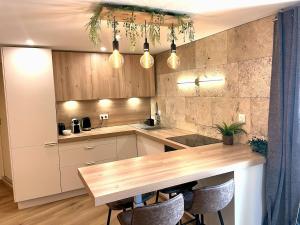 a kitchen with a wooden table and some lights at Le Barral in Voiron