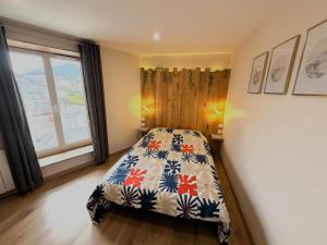 a bedroom with a bed with a floral bedspread at Le Barral in Voiron