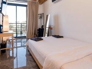 a white bed in a room with a large window at Casa Surf & Ola in San Felipe de Puerto Plata