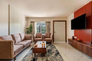 a living room with a couch and a flat screen tv at Vaga Valley in Vagamon +5 photos