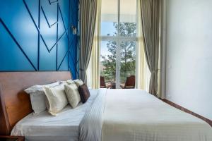 a bedroom with a bed with a blue wall at Vaga Valley in Vagamon