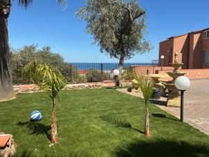 two palm trees and a volley ball on a lawn at Roccazzo 16 in Cefalù