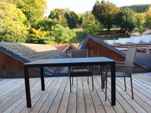 a black table and chairs on a deck at Gîte d'artiste in Sainte-Marie-aux-Mines
