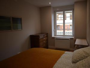 a bedroom with a bed and a dresser and a window at Gîte d'artiste in Sainte-Marie-aux-Mines