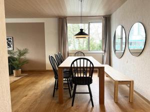 a dining room with a table with chairs and mirrors at Dock and Dwell City Appartment in Bern