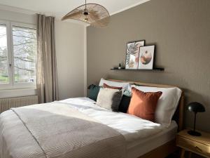 a bedroom with a bed with pillows and a window at Dock and Dwell City Appartment in Bern