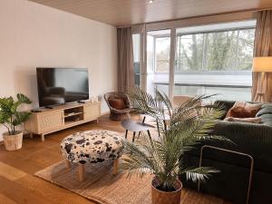 a living room with a couch and a tv at Dock and Dwell City Appartment in Bern