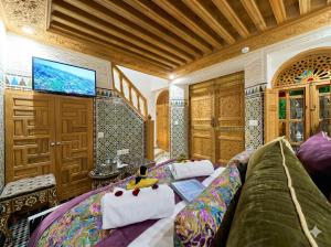 a living room with a couch and a tv at Riad May Fes Original & Spa in Fez