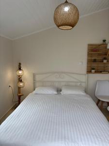 a bedroom with a large white bed with a light fixture at Sea View Residence in Nea Kios +14 photos