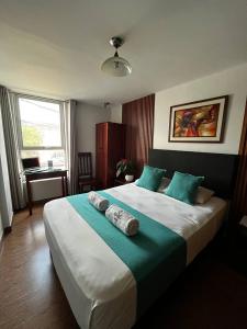 a bedroom with a large bed with two towels on it at Hotel Palmas Reales in Trujillo