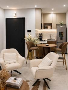 a living room with two chairs and a kitchen at Dakar Roi - Point E - Modern Studio - Central Location in Dakar +12 photos