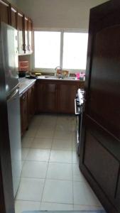 a kitchen with a refrigerator and a tile floor at شقة مفروشة in Ajloun +9 photos