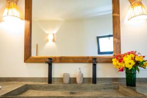 a bathroom with a mirror and a vase of flowers at Adouna Bay in Cap Skirring +32 photos
