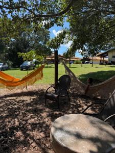 a group of hammocks in a park with a table at Chácara com Piscina, Hidro, Campo de futebol, Beach Tennis, Sinuca e Churrasqueira in Analândia