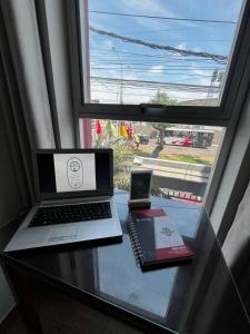 a laptop computer sitting on a glass table next to a window at Hotel Palmas Reales in Trujillo