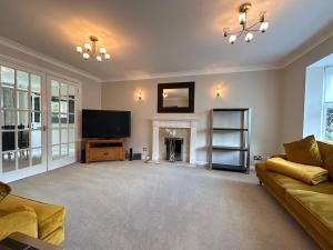 a living room with a television and a fireplace at Spacious 4 Bed Home near Elizabeth Line, great for Contractors, Families, Groups & Insurance stays in Romford