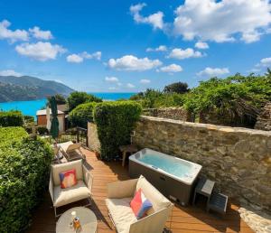 a patio with a jacuzzi tub on a stone wall at Madüneta 5 Terre in Corniglia