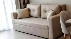a couch sitting in a living room next to a window at Crystal by Solid Sea View Mamaia - Apartament langa plaja cu vedere la mare in Mamaia