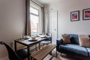 a living room with a table and a blue couch at 3 Bedroom House By Cozy Quarters Property Management Contractors Accommodation Seaham Near Sea in Seaham