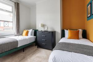 a bedroom with two beds and a dresser and a window at 3 Bedroom House By Cozy Quarters Property Management Contractors Accommodation Seaham Near Sea in Seaham