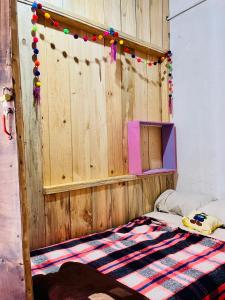 a bedroom with a bed with a wooden wall at Casa 74 hostel in Comitán +5 photos