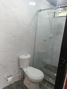 a bathroom with a toilet and a glass shower at Cabaña La Rivera in Macanal
