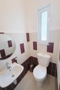 a bathroom with a toilet and a sink at Cozy Home in Delvinë