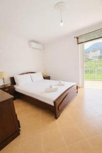 a bedroom with a bed and a large window at Cozy Home in Delvinë