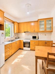 a kitchen with wooden cabinets and a wooden table at Cozy Home in Delvinë
