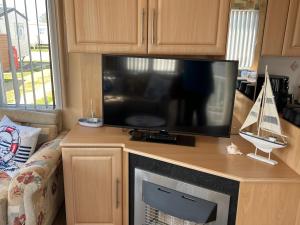 a flat screen tv sitting on top of a entertainment center at 50 Seaview Ingoldmells in Ingoldmells