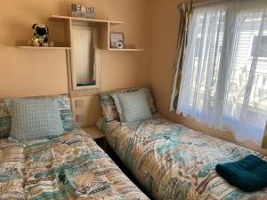 a bedroom with two beds next to a window at 50 Seaview Ingoldmells in Ingoldmells