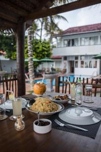a table with plates of food on top of it at Edelweiss Resort in Mirissa