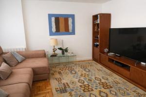a living room with a couch and a flat screen tv at La Bahía in Baiona