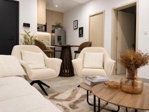 a living room with two chairs and a table at Dakar Roi - Point E - Modern Studio - Central Location in Dakar