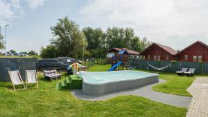 a backyard with a pool and a playground at Luna Port w Rowach in Rowy