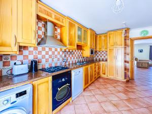 a kitchen with wooden cabinets and a stove top oven at Baleal Bay Guesthouse in Baleal +31 photos