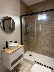 a bathroom with a shower with a sink and a mirror at El Rinconcito de la Jara con Parking para varios coches in Sanlúcar de Barrameda +22 photos