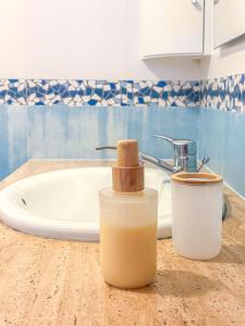 a bathroom counter with a soap dispenser and a sink at Baleal Bay Guesthouse in Baleal