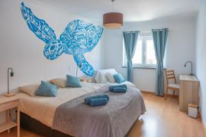 a bedroom with a large bed with blue pillows on it at Baleal Bay Guesthouse in Baleal