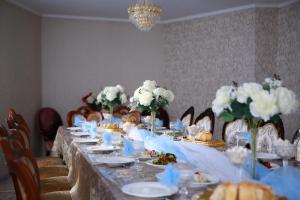a long table with plates of food and flowers on it at Karakol Riviera in Karakol