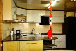 a kitchen with white cabinets and a red ribbon at Karakol Riviera in Karakol +21 photos