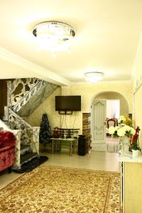 a living room with a couch and a tv at Karakol Riviera in Karakol