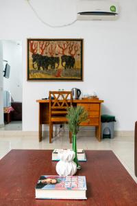 a living room with a table with books and a desk at Edelweiss Resort in Mirissa