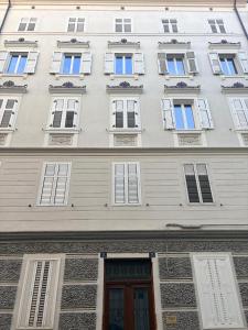 a tall white building with windows and a door at La casa di Sally - Silenzioso Bilocale in centro in Trieste