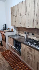 a kitchen with wooden cabinets and a stove top oven at La Terrazza di Rovaglioso in Palmi