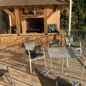 a patio with a table and chairs and a fireplace at Logement au bord de l eau in Dordives