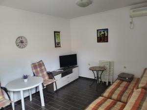 a living room with a couch and a tv and a table at sunny Podaca in Podaca