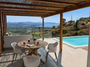 a patio with a table and chairs and a pool at Villa Irene Tolo in Tolo