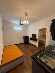 a living room with a couch and a sink at Sunshine Park By RoomzAway in Candolim