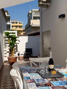 a table with glasses and a bottle of wine on a balcony at Beach house airport in Fiumicino